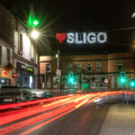 Night photo of O'Connell Street Sligo with the Love Sligo sign lit up and traffic moving in a blur